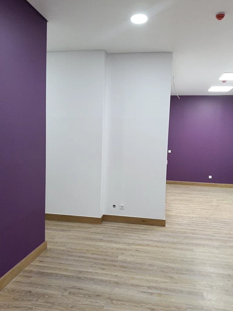 Sala acabada com parede de destaque roxa e chão de madeira
